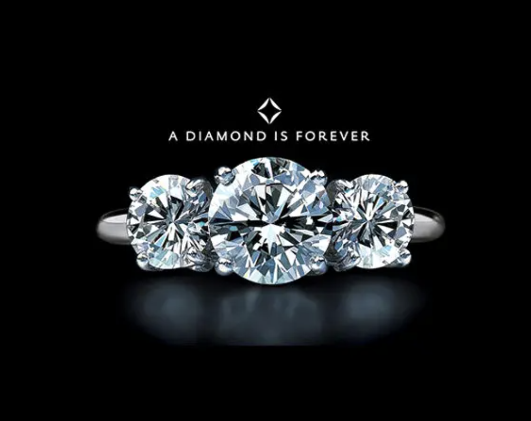 Image of diamond ring set against black background. Tagline â€œA diamond is foreverâ€ for De Beers.